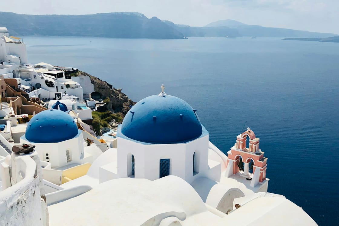 White-washed buildings and blue domes of Oia, Santorini, above the Aegean Sea