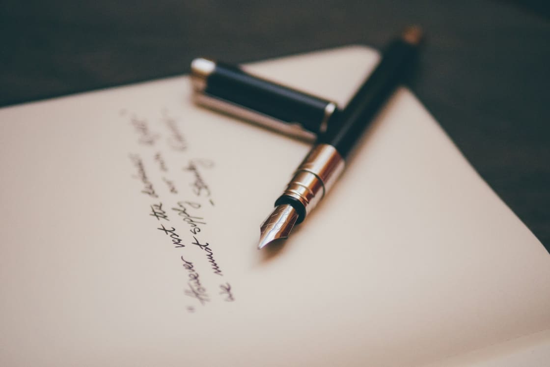Fountain pen resting on handwritten notepaper